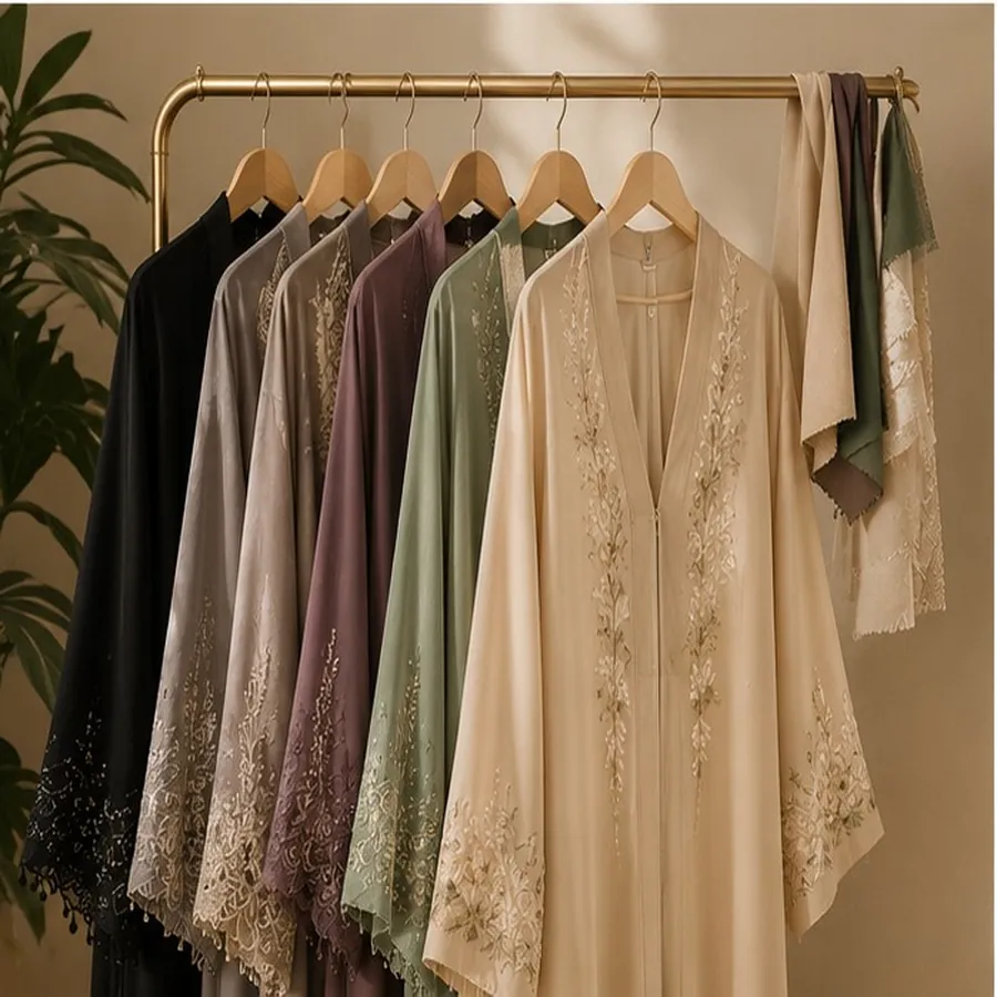 Elegant custom abayas collection hanging on gold rack - modest wear in beige, sage, mauve and black with lace embroidery