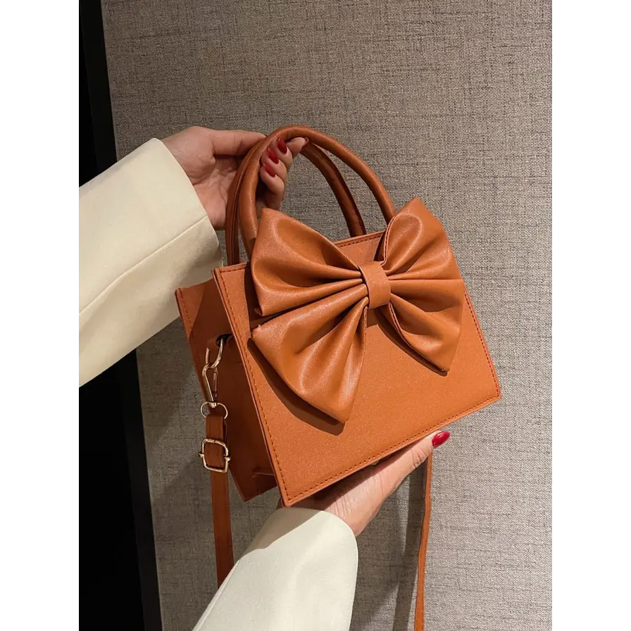 Camel brown faux leather mini tote handbag with large bow knot front, top handles and detachable crossbody strap for women