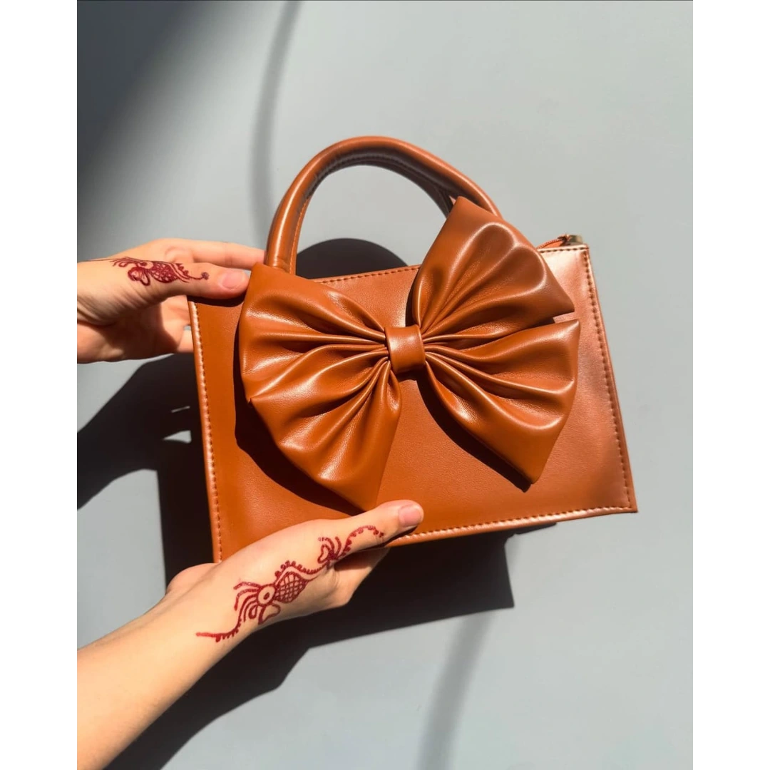 Camel brown faux leather mini tote handbag with large bow knot front, top handles and detachable crossbody strap for women
